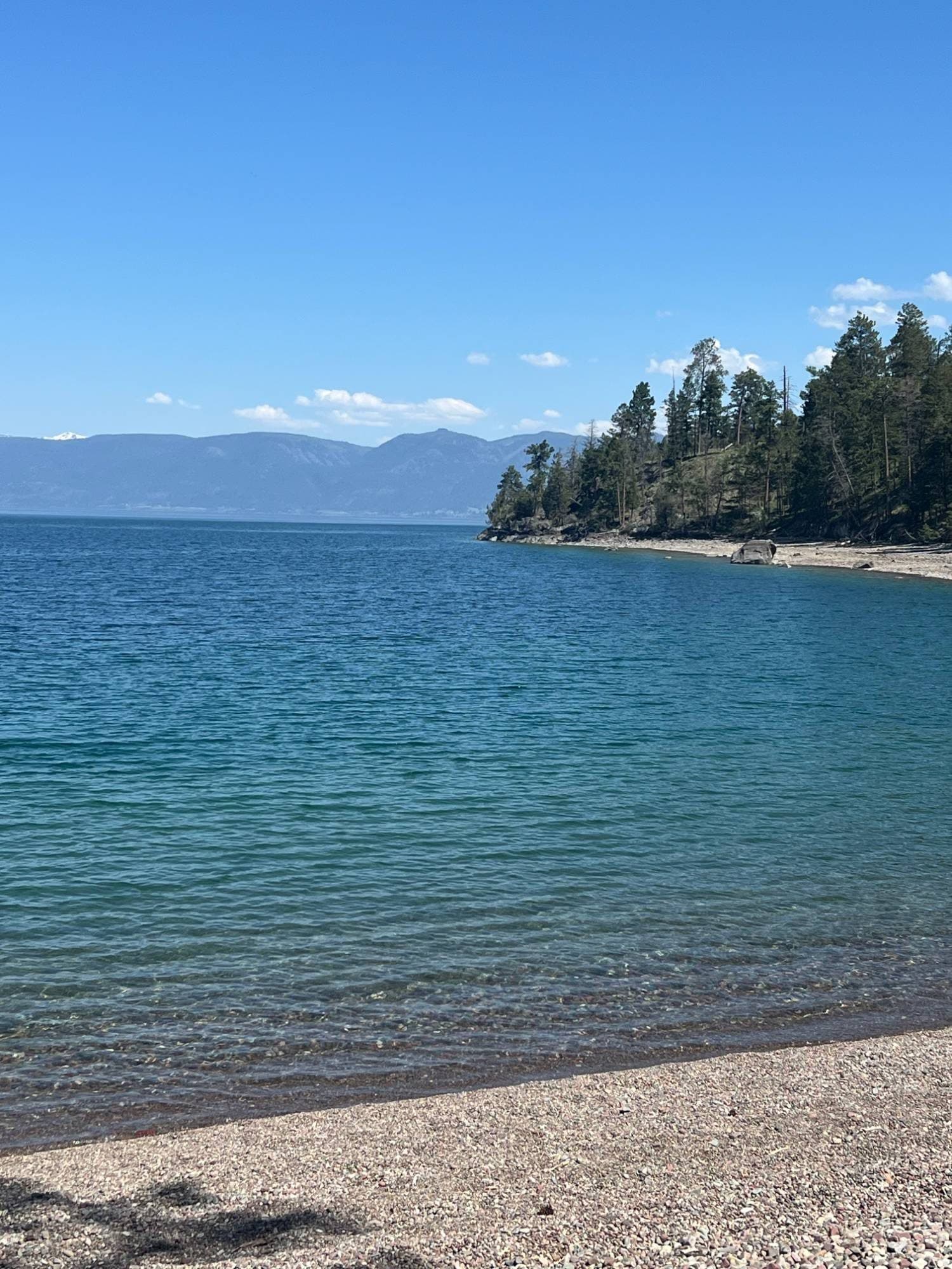 Clear turquoise water and pebble shoreline at Flathead Lake